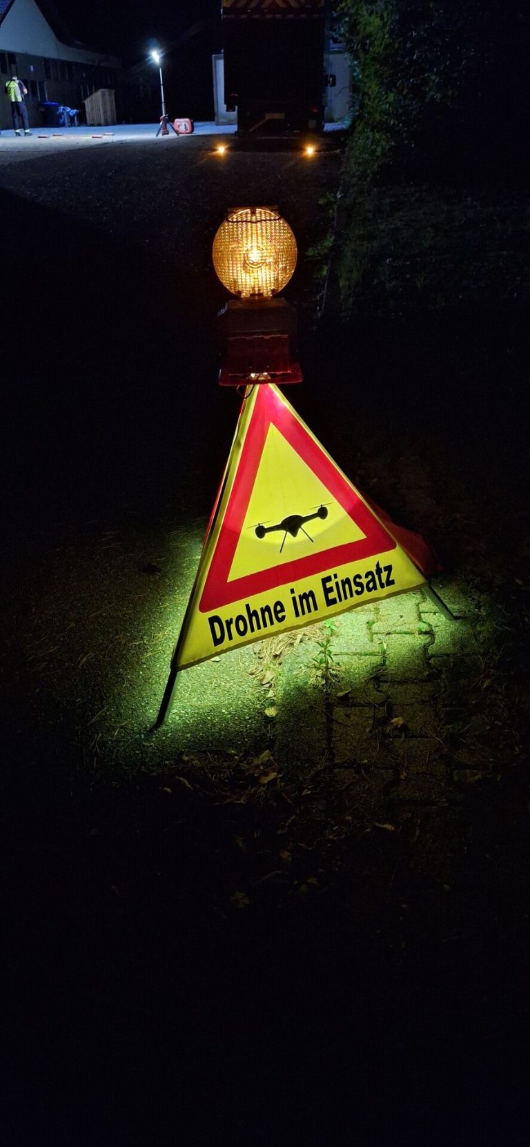 Faltbares Warnschild mit Kennleuchte und dem Symbol „Drohne im Einsatz“ zur Absicherung der Einsatzstelle bei Nacht